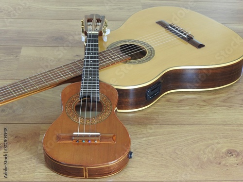 Close-up of an acoustic guitar and a Brazilian string musical instrument: cavaquinho, on a wooden surface. They are widely used to accompany samba and choro, two popular Brazilian rhythms. Top view. photo