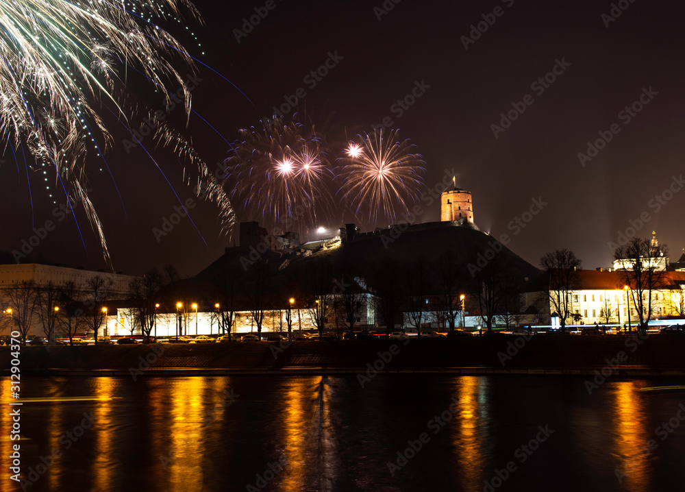 Vilnius, Lithuania - January 01, 2020: Beutifull view to the main firework, at New Year night to Cathedral Square and belfry tower and Cathedral and Gediminas castle with the reflections on the river Vilnius, Lithuania - January 01, 2020: Beutifull view to the main firework, at New Year night to Cathedral Square and belfry tower and Cathedral and Gediminas castle with the reflections on the river