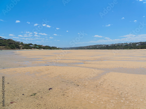 Rippled sand and meandering tide pools on the wide expanse of the Bushman's River estuary at low tide at Kenton on Sea, South Africa.