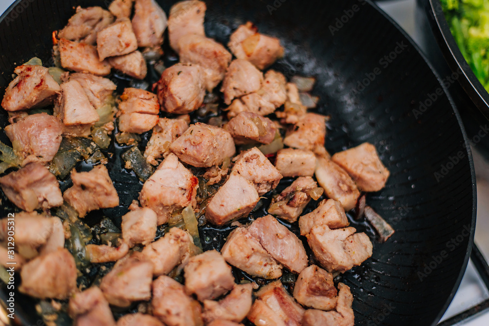 Cooking meat in a pan with onions. Fried chicken. Diced meat Cooking meat in a pan with onions. Fried chicken. Diced meat