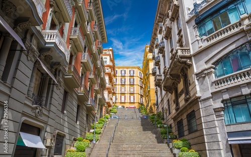 Fototapeta Naklejka Na Ścianę i Meble -  Wide angle photo of italian street with stairs leading up without people in Naples, Italy taken on sunny day.