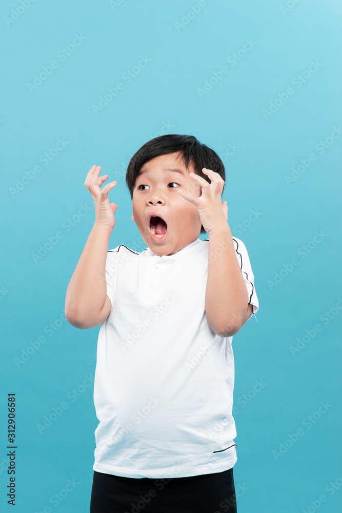 Surprised boy looking up with his hands up. Isolated on white background