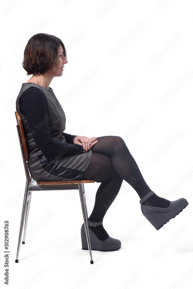 woman in dress sitting on a white background lengs crossed woman in dress sitting on a white background lengs crossed