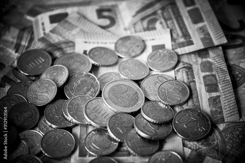 Pile of Euro coins on euro bank money notes of 5, 10 and 20 euro. Black and White editing Pile of Euro coins on euro bank money notes of 5, 10 and 20 euro. Black and White editing