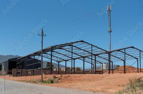 Swellendam, South Africa. December 2019. Metal construction of two barns on farmland in the Wstern Cape, South Africa photo