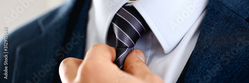 Male arm in blue suit set tie closeup photo