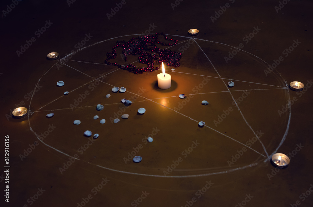 pentagram is painted on the floor, candles are lit, beads are lying ...