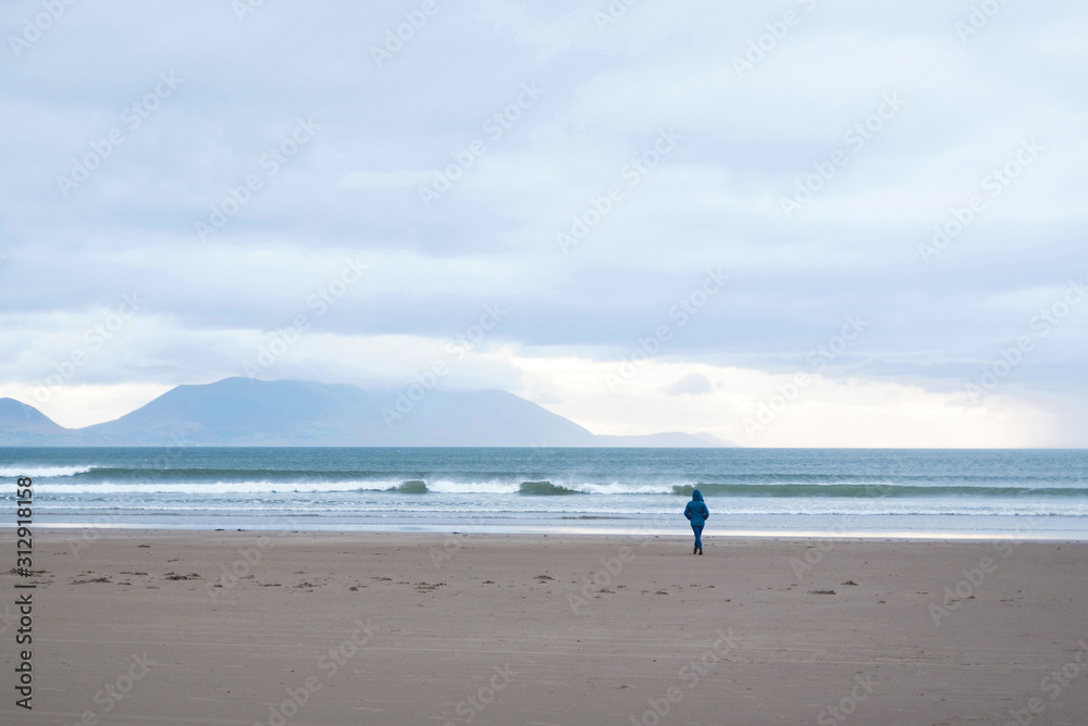woman walking to sea on beach