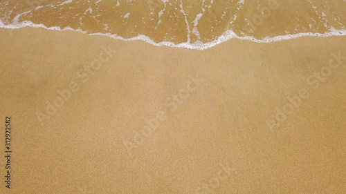 Seaside beach sea water foam transparent - water folws on the beach - golden yellow sand color - summer tourist travel holiday vacation - backgeround close up top down view copy space touristic splash photo