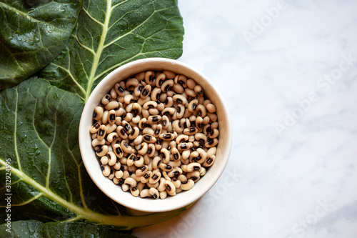 Overhead view of uncooked blackeye peas and collard greens photo