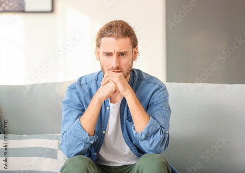 Depressed man sitting on so...