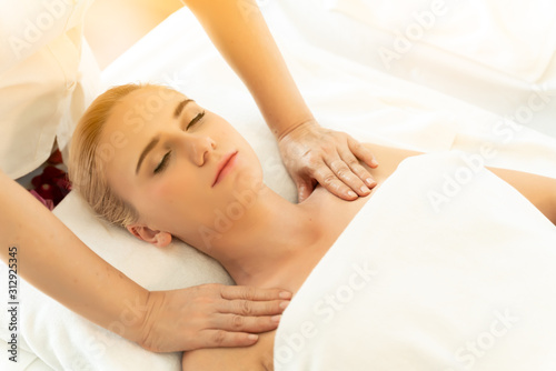 Spa and massage concept.Young caucasian woman with thick eyebrows and perfect skin at white background,facial massage,massage,towel on head,skin care,treatment.beautiful girl relaxes in the spa salon.