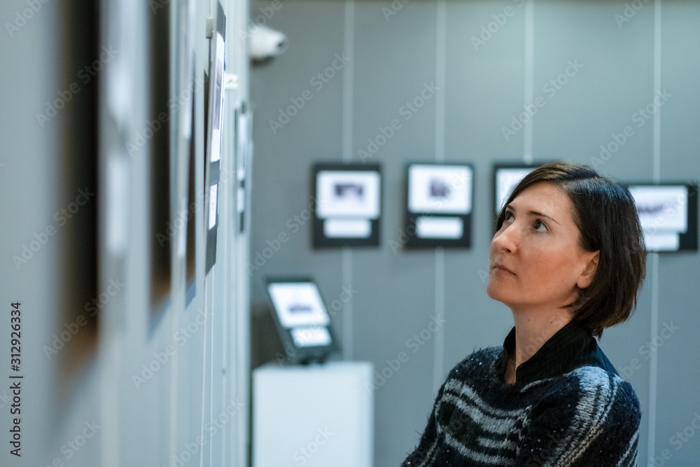 © Ipek Morel - Young Caucasian woman visiting exhibition in modern art gallery