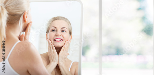 Middle aged woman looking at wrinkles in mirror. Plastic surgery and collagen injections. Makeup. Macro face. Selective focus Free Download Middle aged woman looking at wrinkles in mirror. Plastic surgery and collagen injections. Makeup. Macro face. Selective focus - GFXLoad