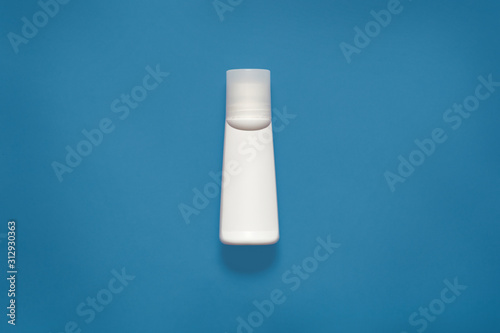 Mockup horizontal picture of white plastic bottle for liquids, cosmetic issues, situated in centre of photo, isolated over phantom blue background. Plastic concept. Copyspace for advertisement.