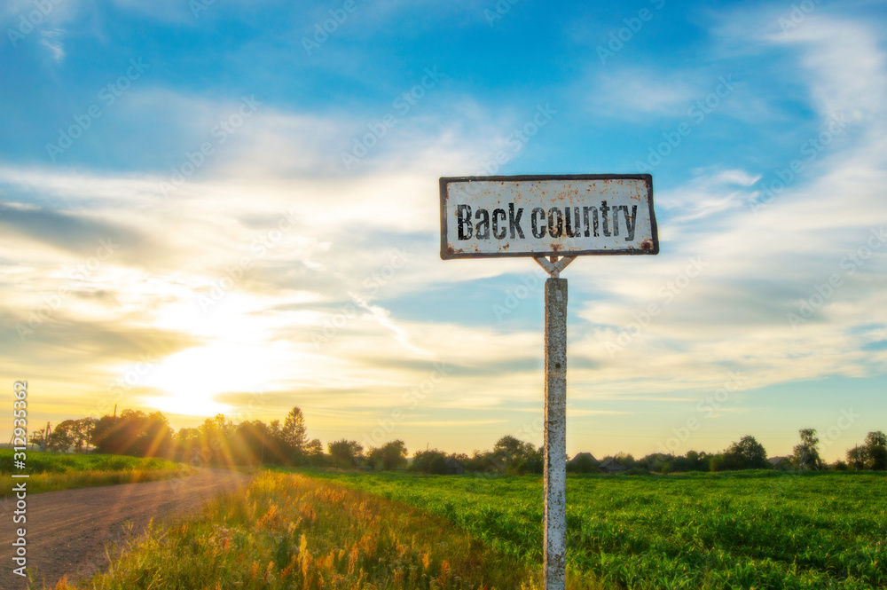 road sign in a beautiful countryside on a summer evening, a great secluded place on a sunset background. Backcountry