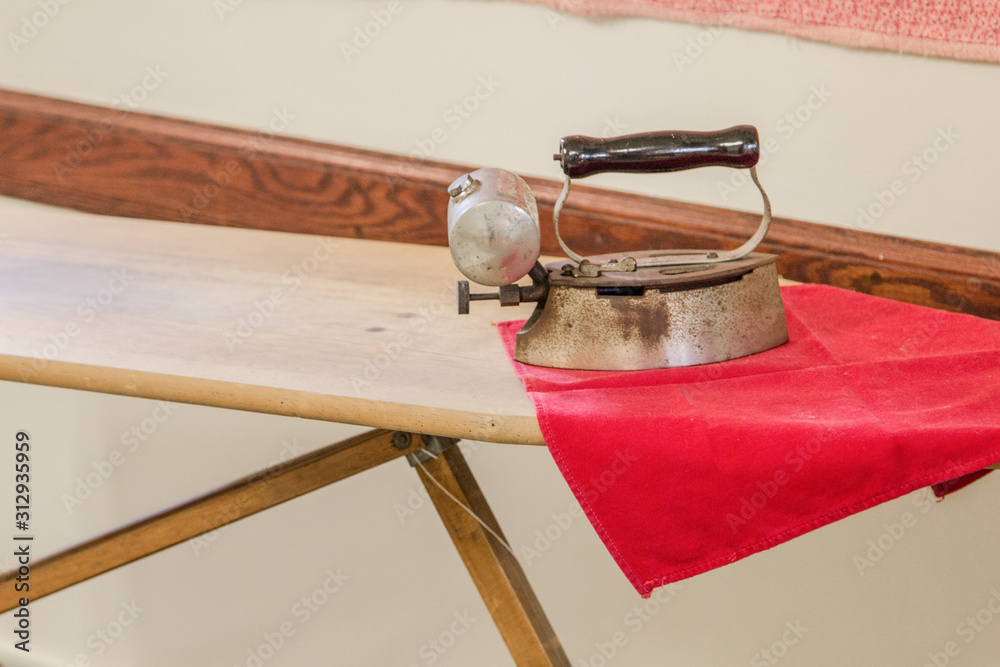 Antique Iron And Ironing Board. Old Fashioned metal clothes iron on