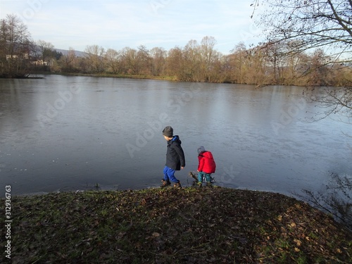 Kinder spielen am zugefrorenen See