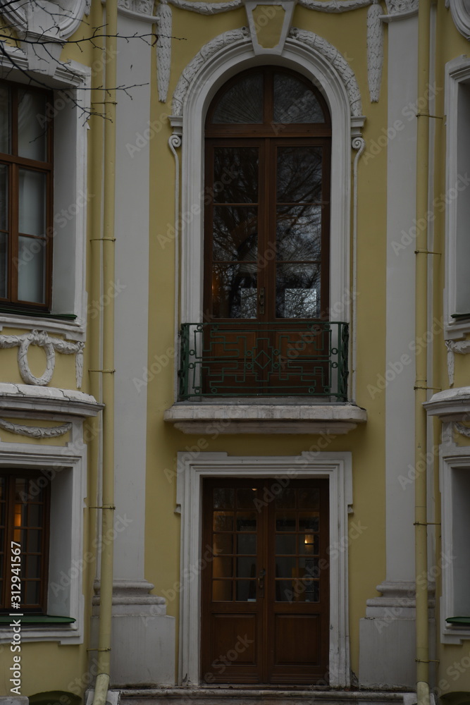 facade of an old building. yellow building façade. sculptures and decorative elements on the facade of buildings. facade of an old building. yellow building façade. sculptures and decorative elements on the facade of buildings.