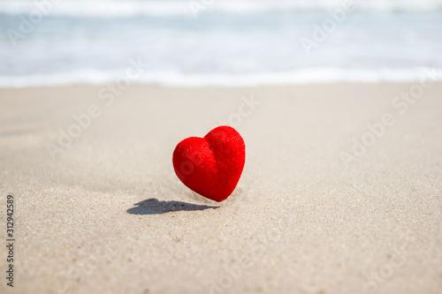 Red heart on a sandy beach. concept Valentine day concept