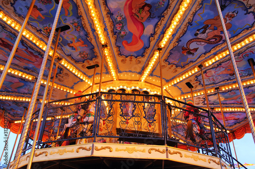 The ceiling of the carousel marry go round with horses. lights on
