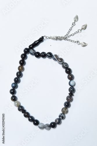 Handmade rosary necklace made of beads, black agate and silver on white Background 