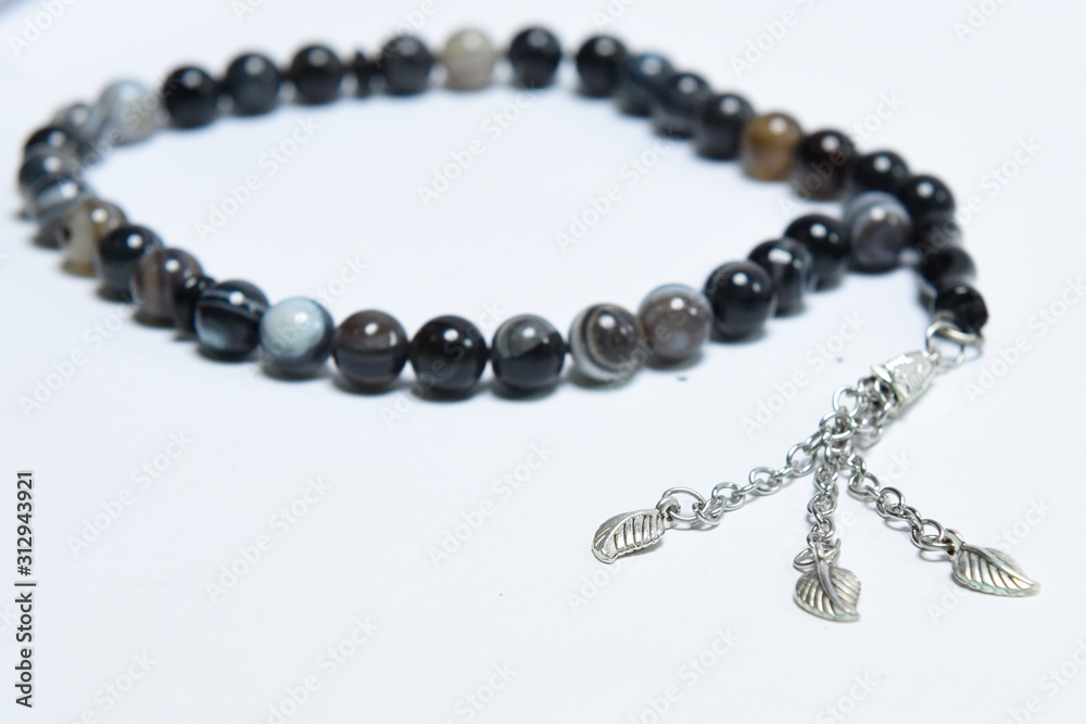 Handmade rosary necklace made of beads, black agate and silver on white Background Handmade rosary necklace made of beads, black agate and silver on white Background