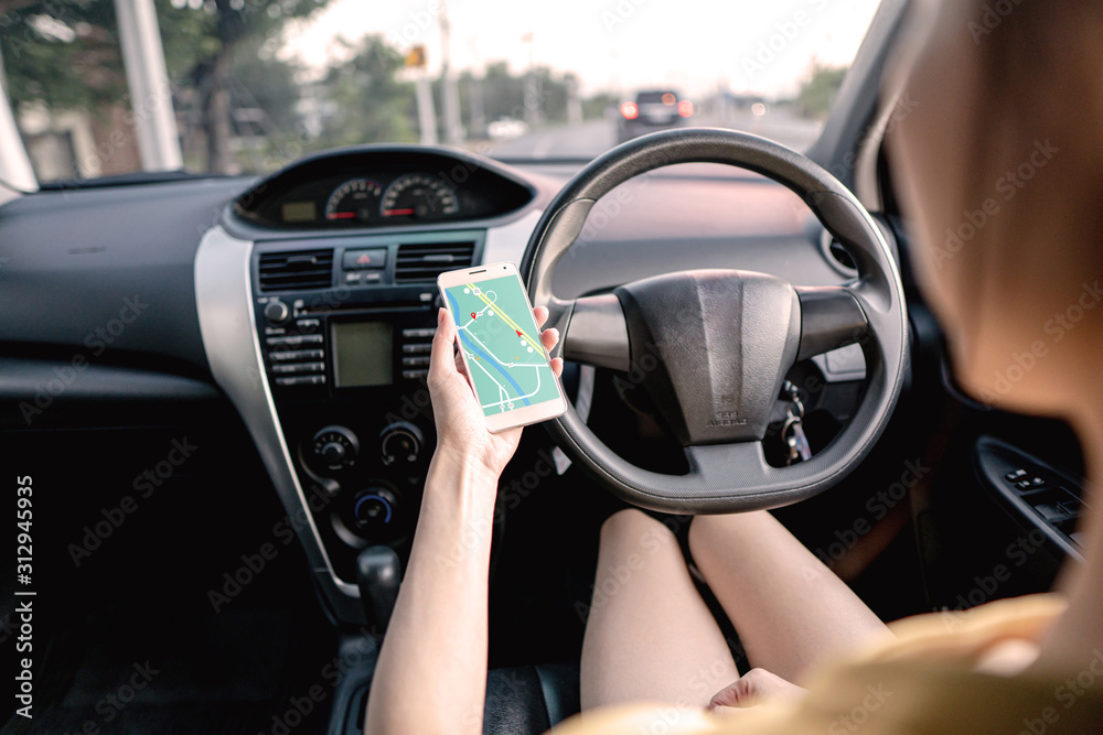 Woman in the car and holding mobile phone with map gps navigation