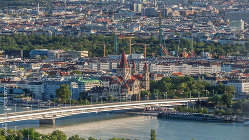 Aerial panoramic view of Vienna city with skyscrapers, historic buildings and a riverside promenade timelapse in Austria.