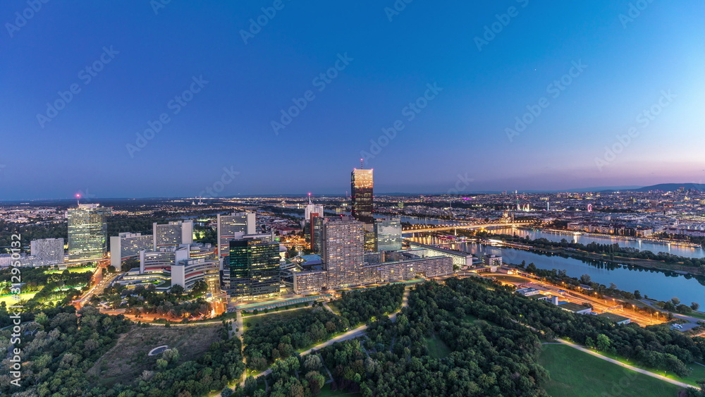 Fototapeta premium Aerial panoramic view over Vienna city with skyscrapers, historic buildings and a riverside promenade day to night timelapse in Austria.