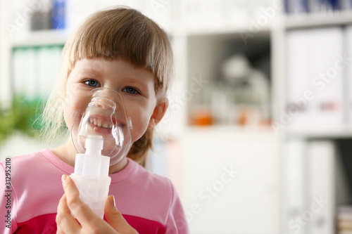 Happy child makes inhalation at home for