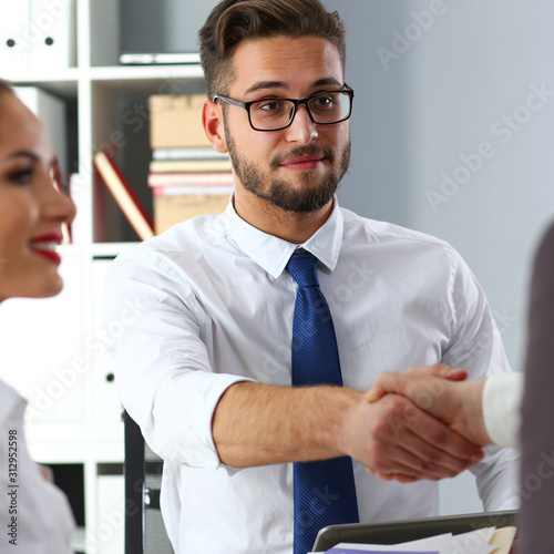 Man in suit and tie give hand as hello in office