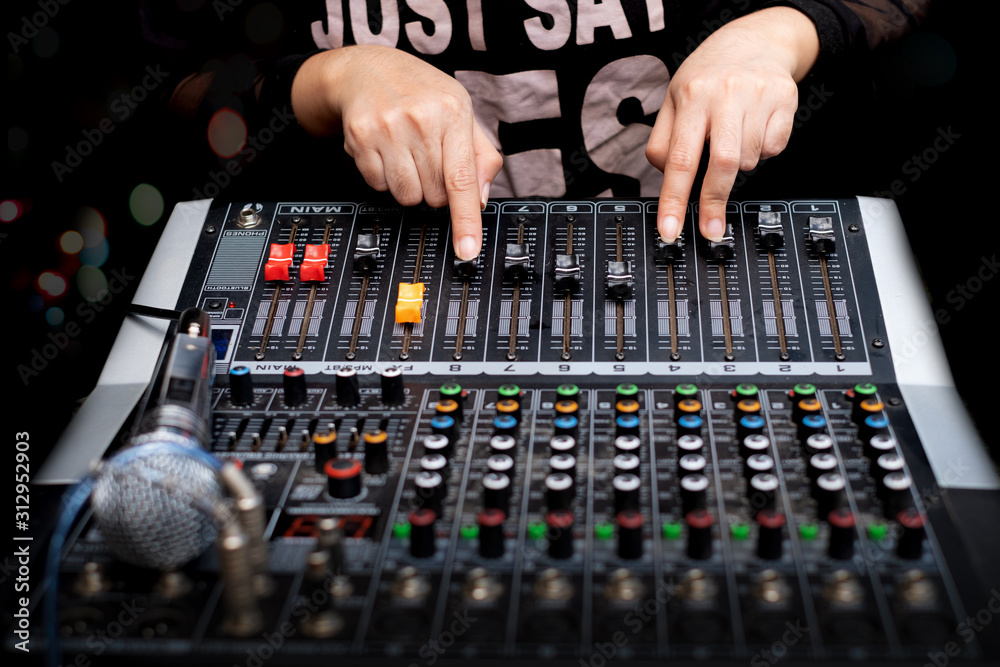 Woman hands mixing audio by sound mixer analog Woman hands mixing audio by sound mixer analog