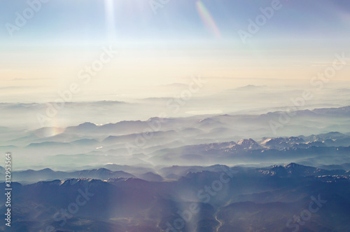 View from the airplane porthole to a mountain landscape