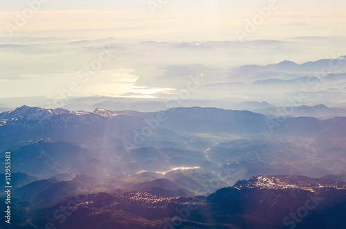 View from the airplane porthole to a mountain landscape