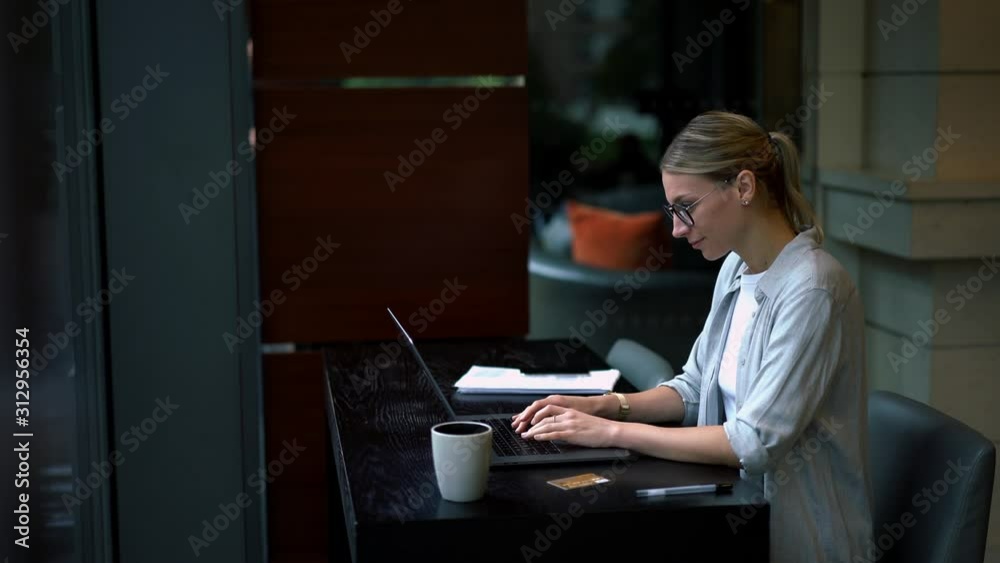 Caucasian woman typing text request on laptop computer for searching information on website using internet connection, positive hipster girl working remotely at modern netbook