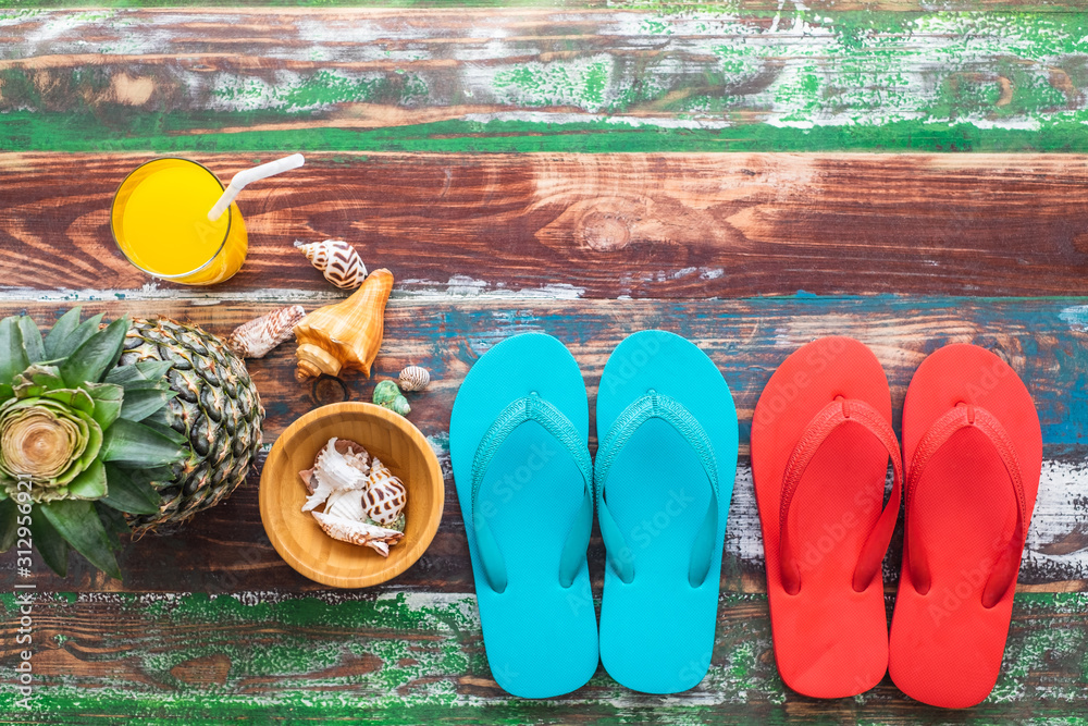 Orange juice pineapple seashell and 2 rubber sandals on color wood background, travel leisure concept.