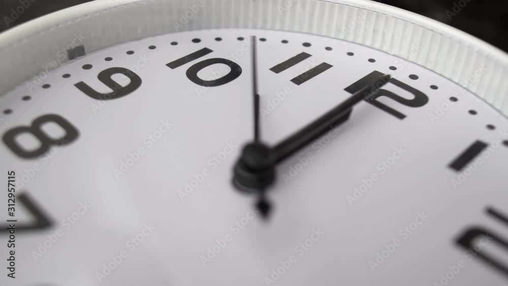 white clock hanging on wall ticking shows twelve o’clock