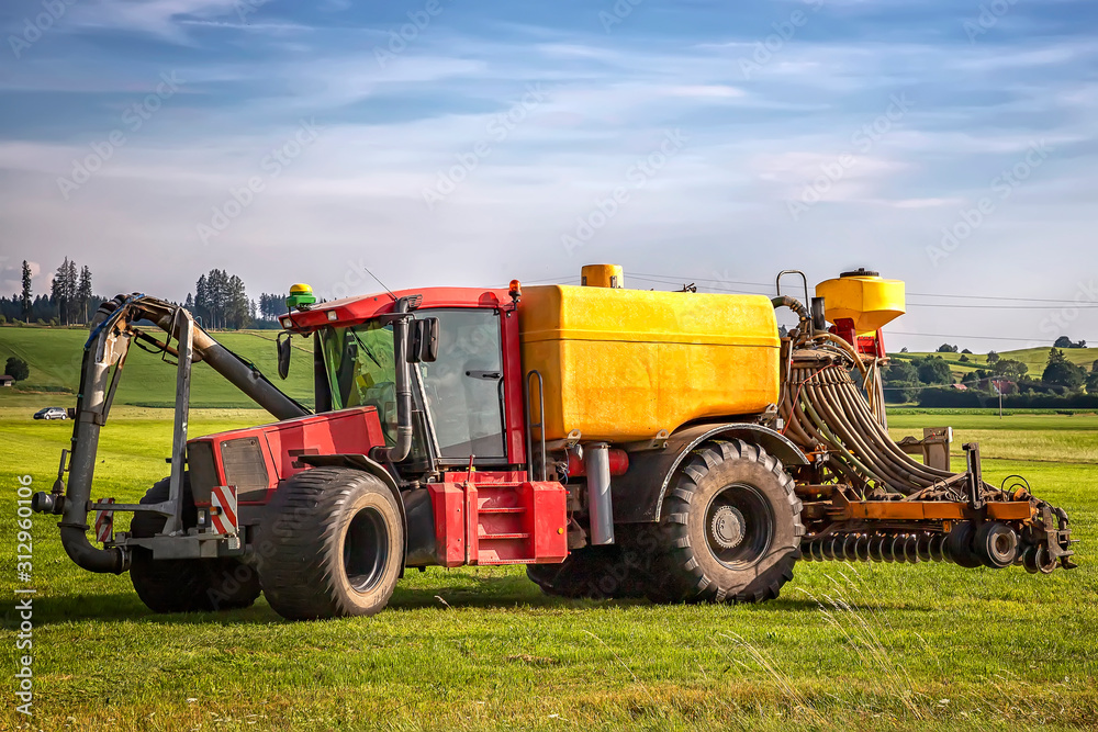 heavy tractor for application of manure on arable farmland at the field in Germany heavy tractor for application of manure on arable farmland at the field in Germany