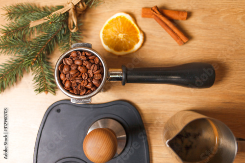 Cup of coffee with  dried orange and fir tree branch and step by making coffee with bean on the table. Copy space
