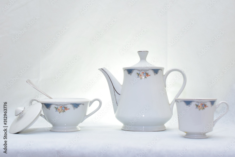 Mock up / design set of elegant and traditional teapot colorful white and blue coffee cup & Tea cup on cup's plate beside the hot tea pot , design/ drink-ware isolated on white background Mock up / design set of elegant and traditional teapot colorful white and blue coffee cup & Tea cup on cup's plate beside the hot tea pot , design/ drink-ware isolated on white background