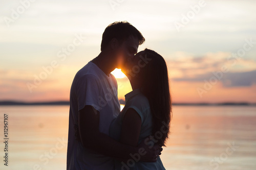 loving couple kissing at sunset. love in the sun. Valentine's day in nature beach