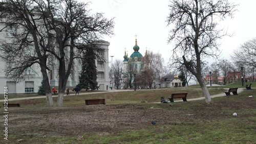 The panorama of Kiev in the area of the Andreevsky Church shows the St. Andrew's Church itself and part of the building of the historical museum, passers-by cyclist walks. photo