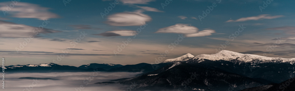 scenic view of snowy mountains with white fluffy clouds in evening, panoramic shot scenic view of snowy mountains with white fluffy clouds in evening, panoramic shot