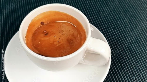 coffee drop falling in super slow motion inside of cup of espresso italian coffee with foam on black background, food and drink and relax photo