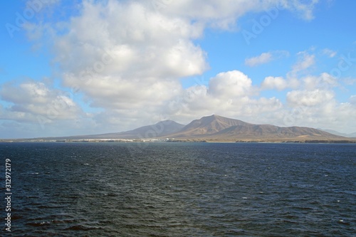 View from the Atlantic Ocean to the Canary Islands. Blue sky and skyline. White clouds and mountains