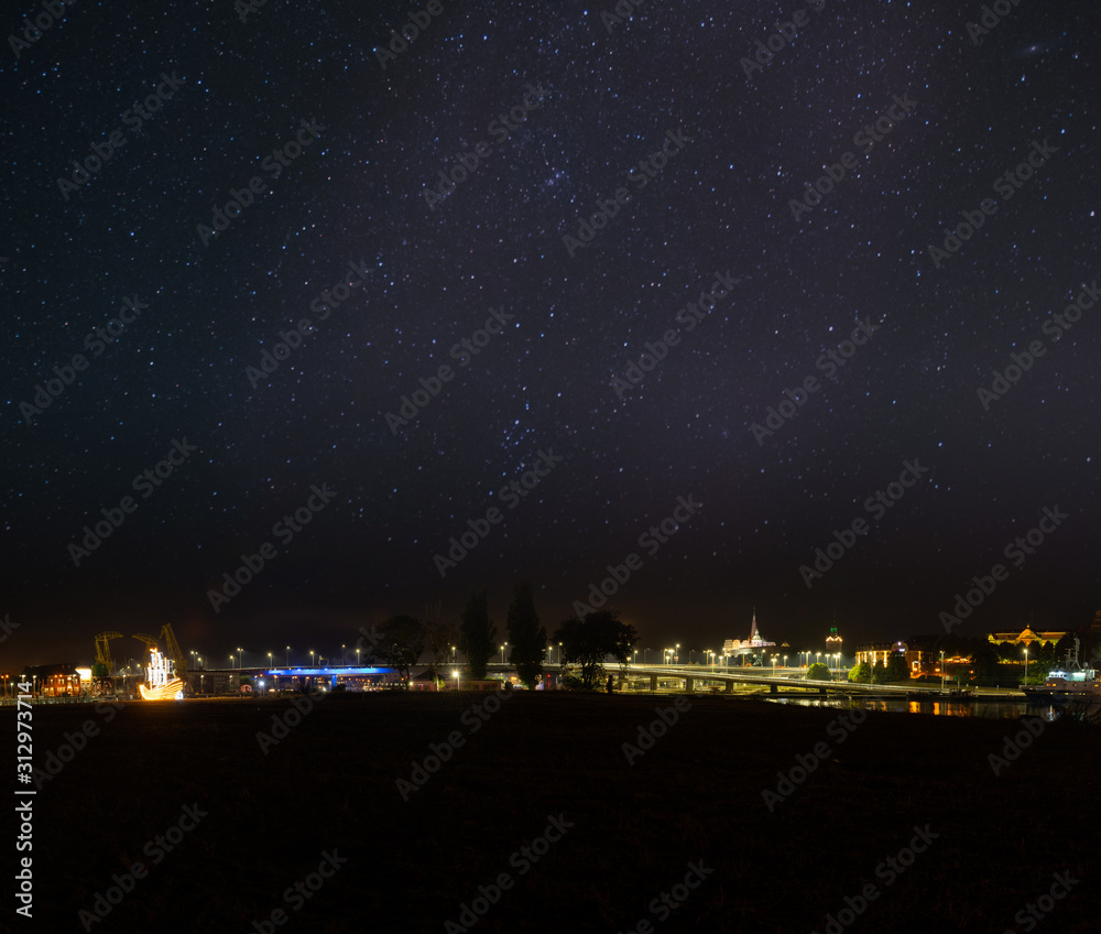 Szczecin. Night view from across the river to the illuminated historic center. Odra river. Chrobry embankments in Szczecin