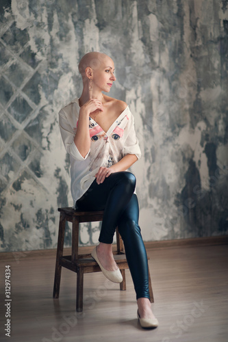 Portrait of beautiful middle woman patient with cancer with shaved head without hair. Emotions, hope in the eyes