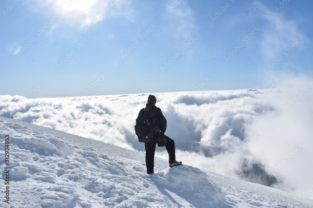 Lonely mountaineer get rest on snowy mountain high above the clouds. Happy climber enjoy in view from top of Dry Mountain, Serbia Lonely mountaineer get rest on snowy mountain high above the clouds. Happy climber enjoy in view from top of Dry Mountain, Serbia
