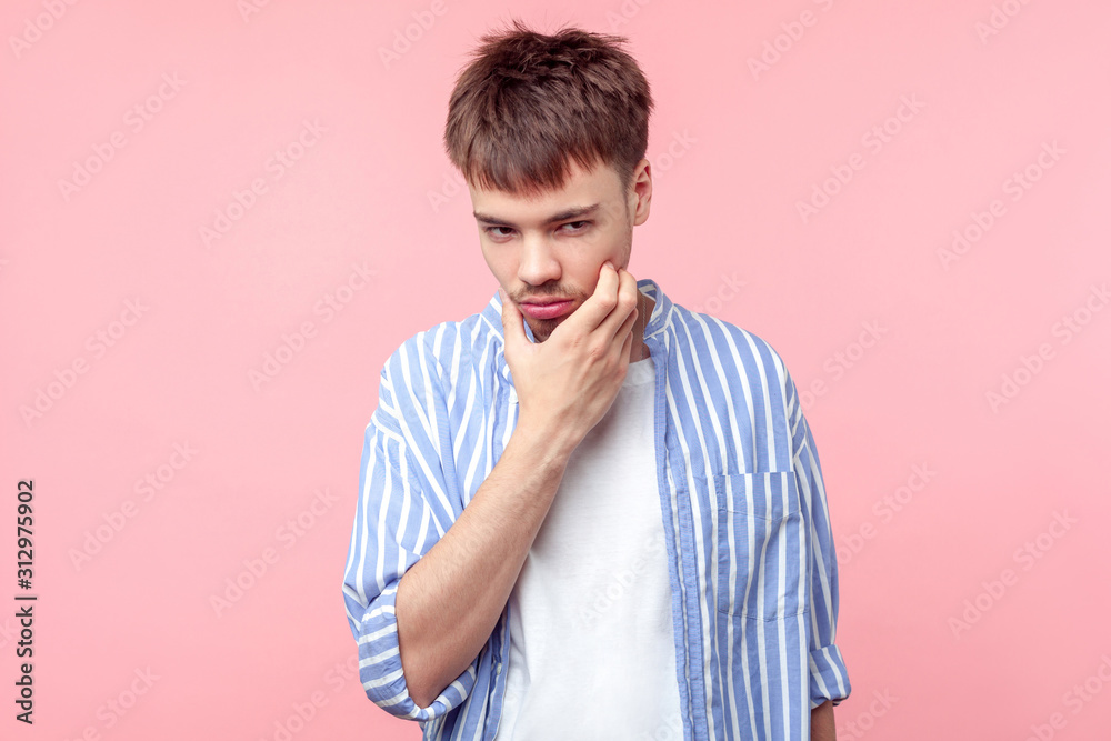 Portrait of pensive brown-haired man with small beard and mustache in casual shirt touching his chin, thinking over plan with sly face expression. indoor studio shot isolated on pink background Portrait of pensive brown-haired man with small beard and mustache in casual shirt touching his chin, thinking over plan with sly face expression. indoor studio shot isolated on pink background